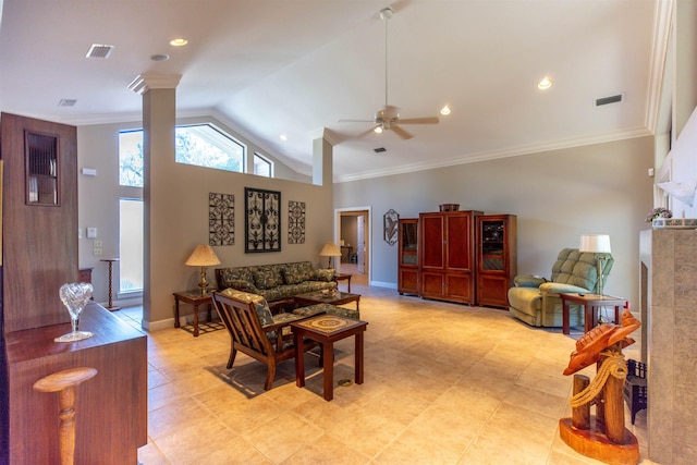 living room with lofted ceiling, ornamental molding, a tile fireplace, ceiling fan, and decorative columns