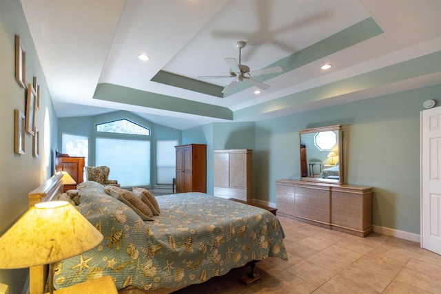 bedroom featuring light tile patterned floors, ceiling fan, and a tray ceiling