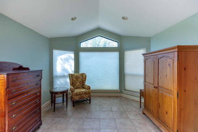 living area featuring lofted ceiling and light tile patterned floors