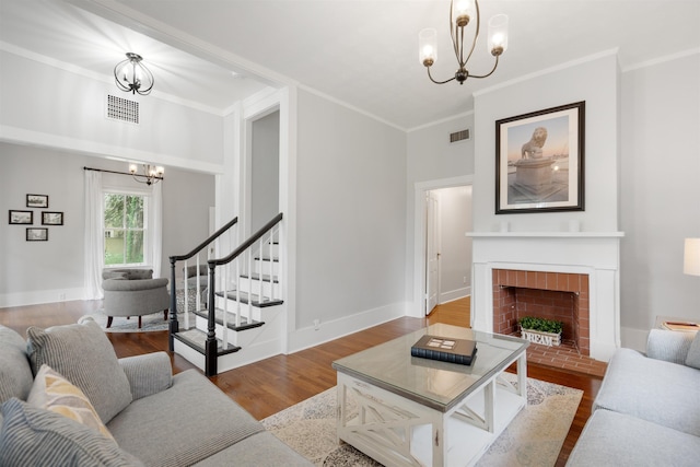 living room with a chandelier, a fireplace, ornamental molding, and light hardwood / wood-style flooring