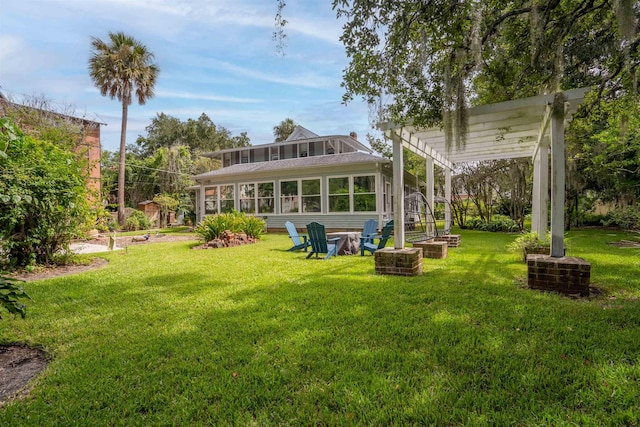 back of property with a pergola, a lawn, and a sunroom