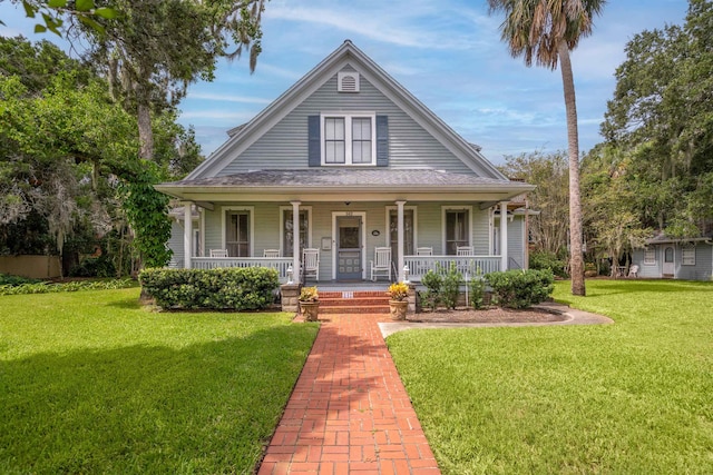 country-style home featuring covered porch and a front yard