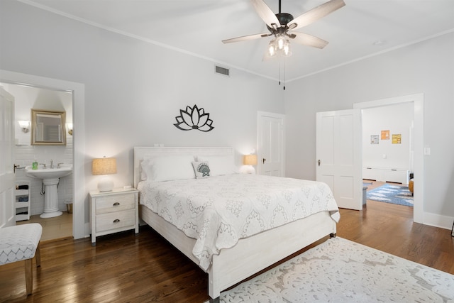 bedroom with dark hardwood / wood-style floors, ensuite bath, ceiling fan, and ornamental molding