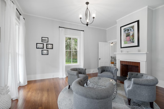 living room featuring a fireplace, dark hardwood / wood-style flooring, an inviting chandelier, and ornamental molding