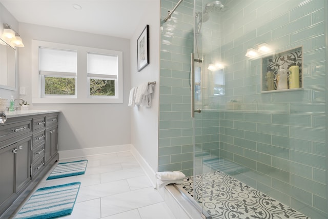 bathroom with tile patterned floors, vanity, and a tile shower