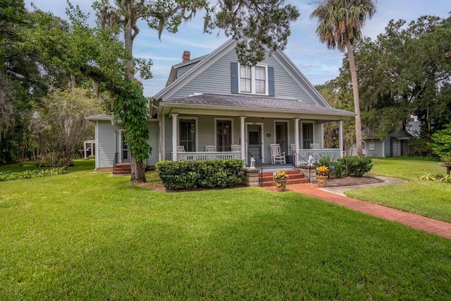 farmhouse featuring covered porch and a front lawn