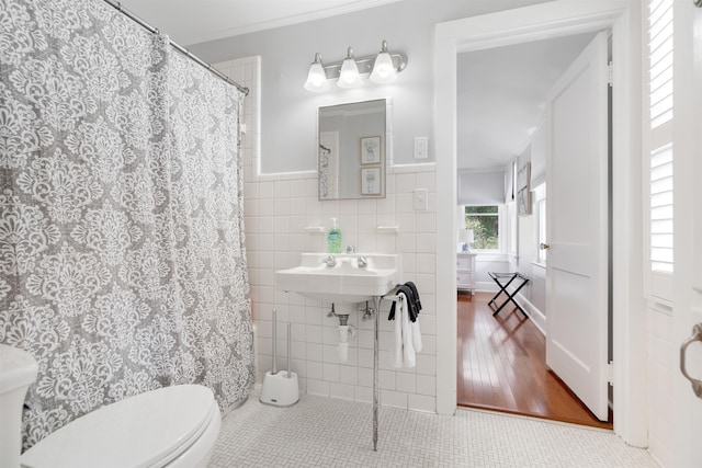 bathroom with walk in shower, hardwood / wood-style floors, toilet, tile walls, and ornamental molding