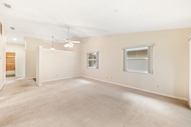 carpeted spare room featuring ceiling fan, a textured ceiling, and vaulted ceiling