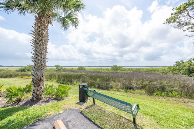 view of property's community with a yard and a water view