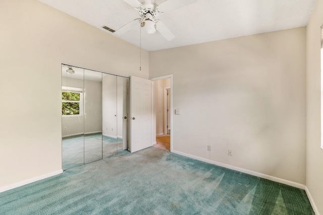 unfurnished bedroom with ceiling fan, a closet, carpet, and lofted ceiling