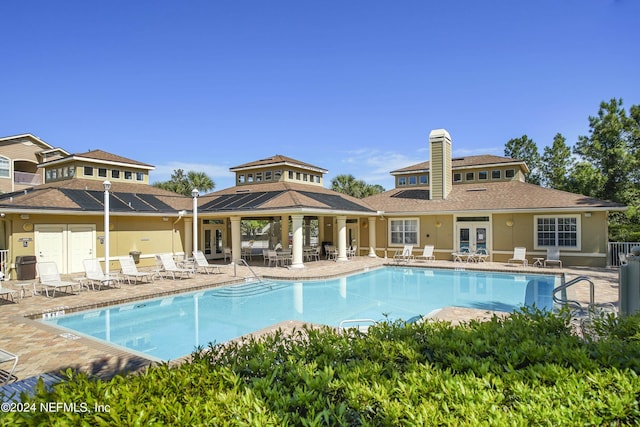 view of swimming pool featuring french doors and a patio