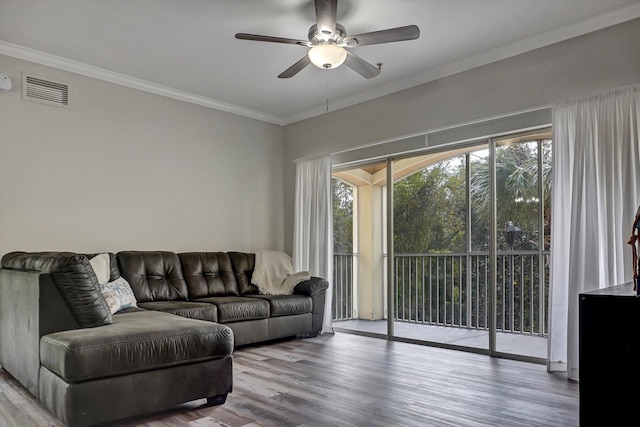 living room featuring ceiling fan, wood-type flooring, and crown molding