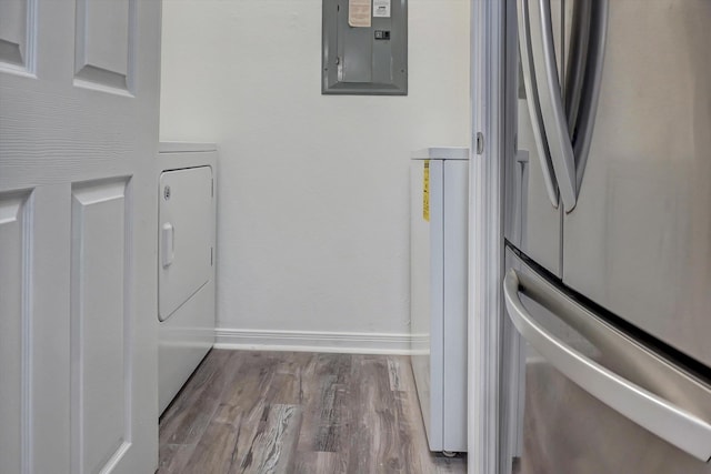 interior space with electric panel, stainless steel fridge, light hardwood / wood-style flooring, and washer / clothes dryer