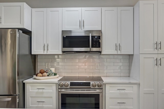 kitchen featuring backsplash, light stone counters, white cabinets, and appliances with stainless steel finishes