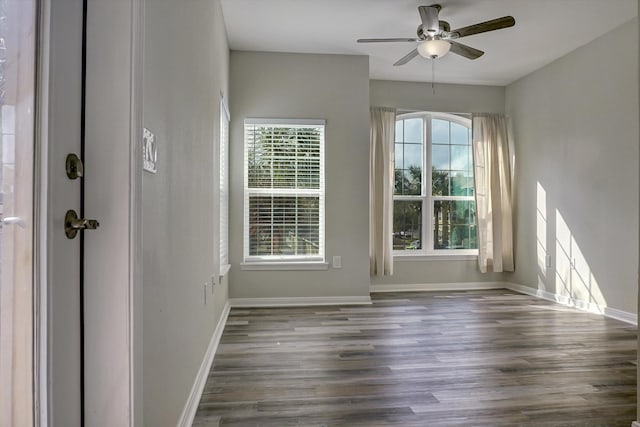 unfurnished room featuring ceiling fan and dark wood-type flooring