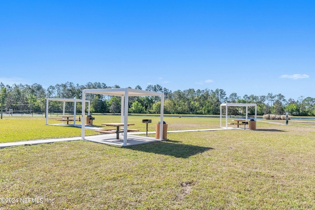 view of property's community featuring a pergola and a lawn