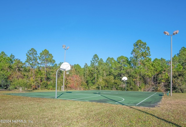 view of basketball court with a yard