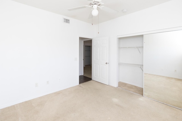 unfurnished bedroom featuring ceiling fan, a closet, and light carpet