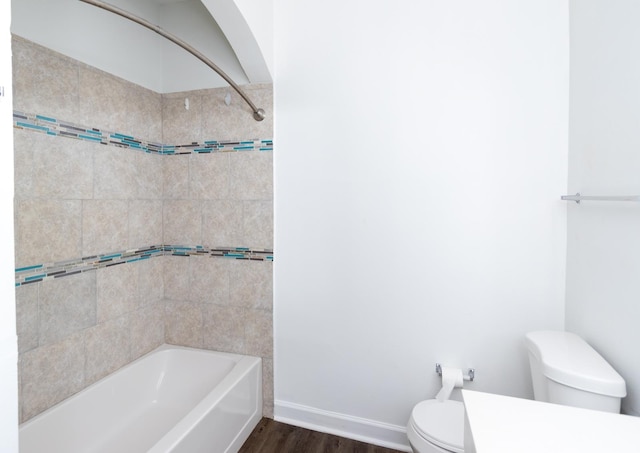 bathroom featuring hardwood / wood-style floors, toilet, and tiled shower / bath