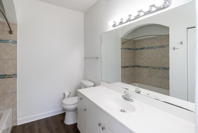 full bathroom featuring toilet, tiled shower / bath, hardwood / wood-style flooring, and vanity