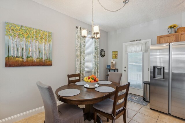 133 Pomar St, Saint Augustine, FL 32084 - dining space with light tile patterned floors, a textured ceiling, and a chandelier