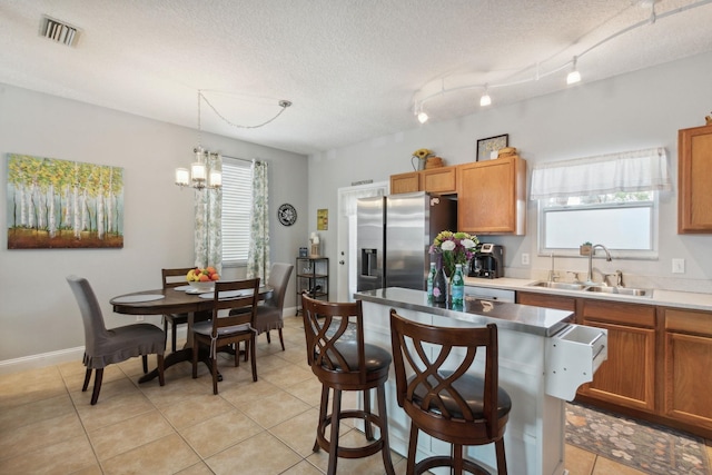 133 Pomar St, Saint Augustine, FL 32084 - kitchen featuring stainless steel refrigerator with ice dispenser, healthy amount of natural light, a chandelier, light tile patterned floors, and a textured ceiling
