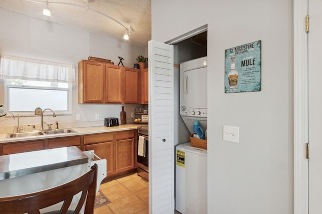 133 Pomar St, Saint Augustine, FL 32084 - kitchen with estacked washer and dryer, stainless steel range, rail lighting, light tile patterned floors, and light countertops