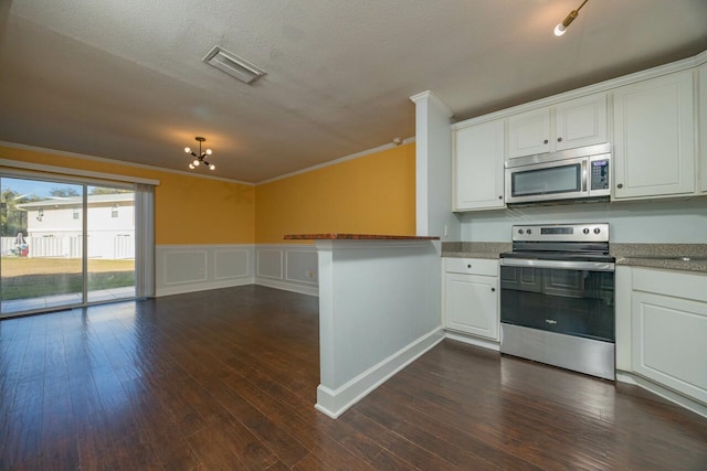 4420 Carter Rd Unit 27, Saint Augustine, FL 32086 - kitchen featuring appliances with stainless steel finishes, ornamental molding, white cabinets, a peninsula, and open floor plan