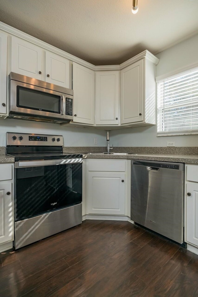 kitchen with sink, white cabinets, dark hardwood / wood-style flooring, and appliances with stainless steel finishes