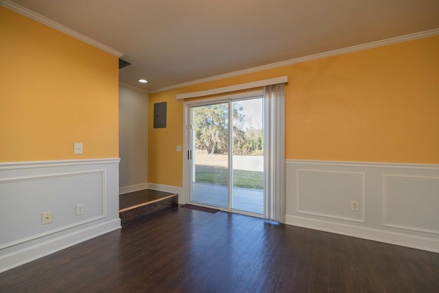 spare room featuring electric panel, ornamental molding, and dark wood-type flooring