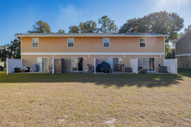 back of property with a patio area, central AC, and a yard