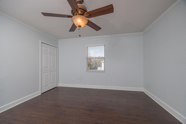 empty room featuring ceiling fan, crown molding, and dark hardwood / wood-style flooring