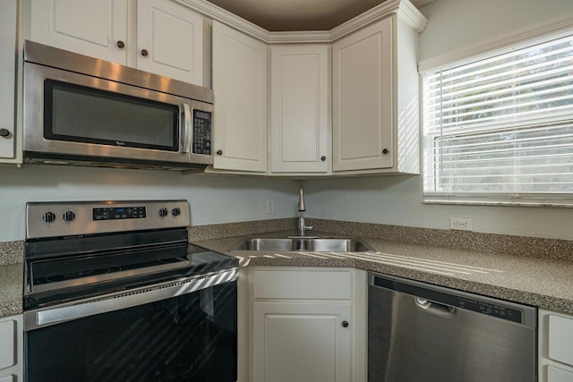 kitchen featuring white cabinets, appliances with stainless steel finishes, and sink