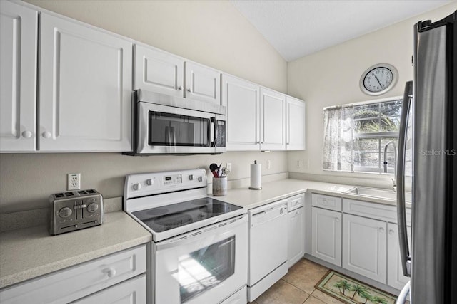 2001 Palm Dr Unit 101, Flagler Beach, FL 32136 - kitchen with light countertops, light tile patterned floors, white cabinets, lofted ceiling, and stainless steel appliances