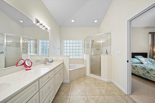 2001 Palm Dr Unit 101, Flagler Beach, FL 32136 - ensuite bathroom with double vanity, connected bathroom, a bath, tile patterned floors, and a stall shower