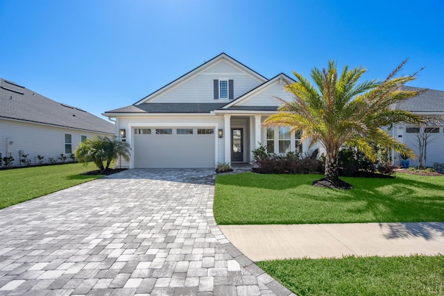 view of front of house with a front lawn, decorative driveway, and an attached garage