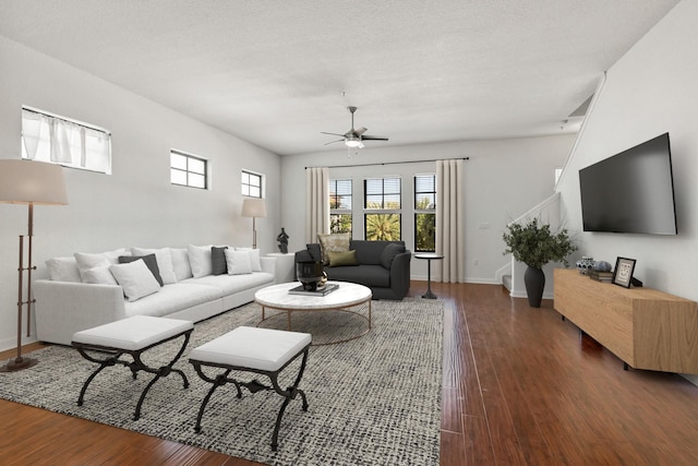 living room with a textured ceiling, dark hardwood / wood-style floors, and ceiling fan