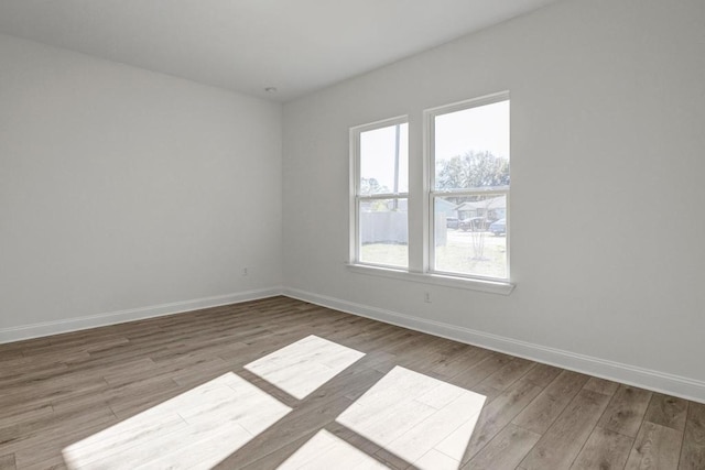 spare room featuring wood finished floors and baseboards