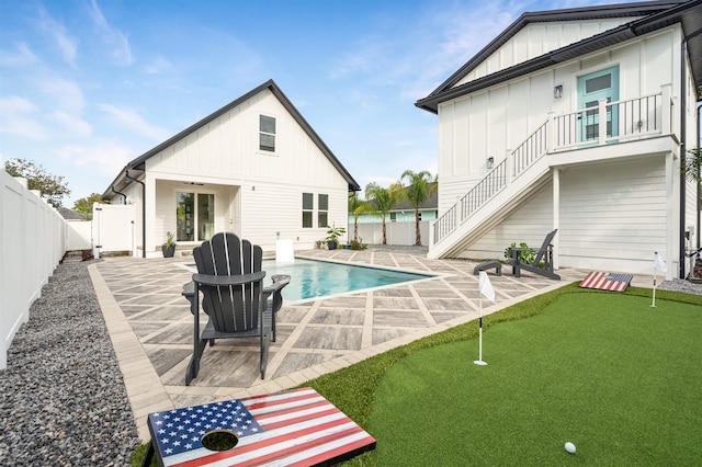 rear view of house featuring ceiling fan, a balcony, a fenced in pool, and a patio