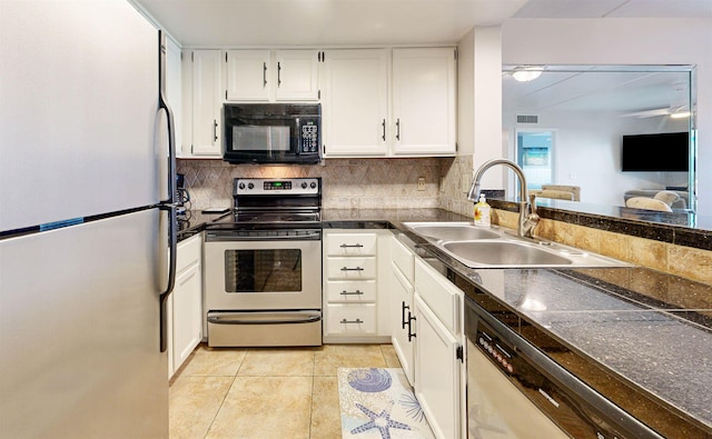 880 A1A Beach Blvd Unit 6101, Saint Augustine, FL 32080 - kitchen featuring stainless steel appliances, a sink, dark countertops, white cabinetry, and decorative backsplash