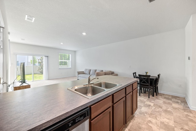 kitchen with a textured ceiling, stainless steel dishwasher, and sink