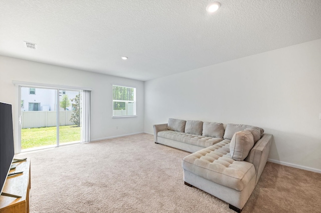 carpeted living room featuring a textured ceiling