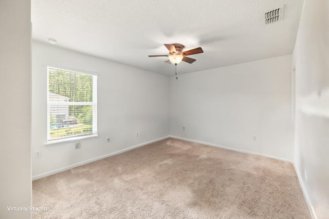 carpeted empty room featuring ceiling fan and a textured ceiling