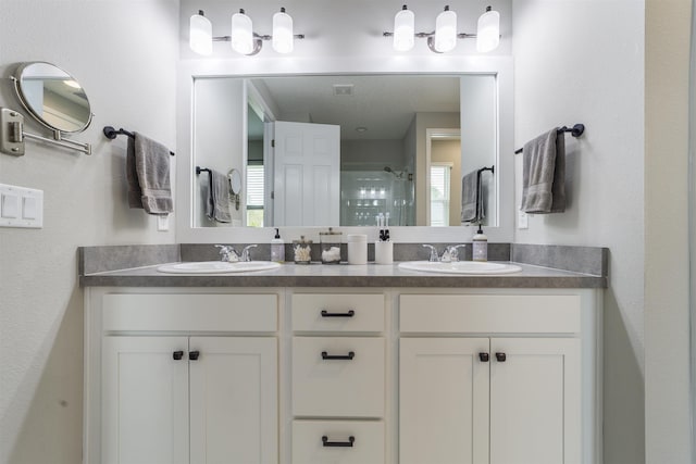 bathroom with a shower with door and vanity