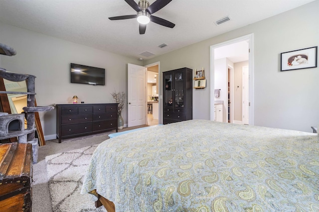 bedroom featuring ensuite bathroom, ceiling fan, and light colored carpet