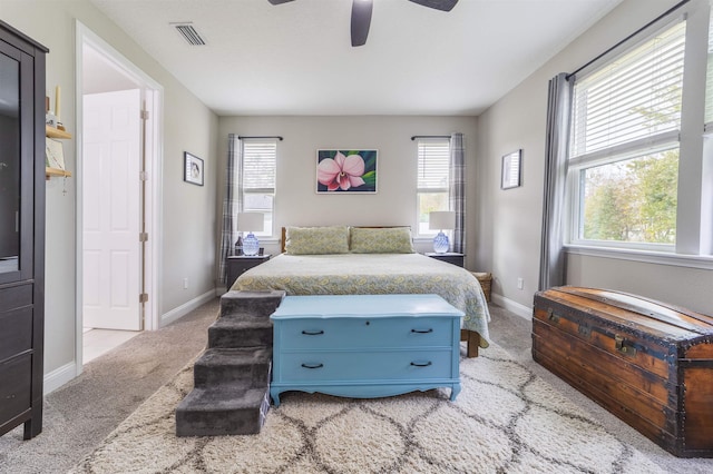 carpeted bedroom featuring multiple windows and ceiling fan