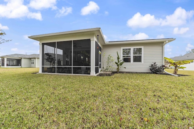 rear view of property featuring a sunroom and a lawn