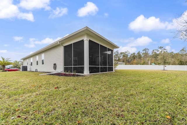 rear view of property with a lawn and a sunroom