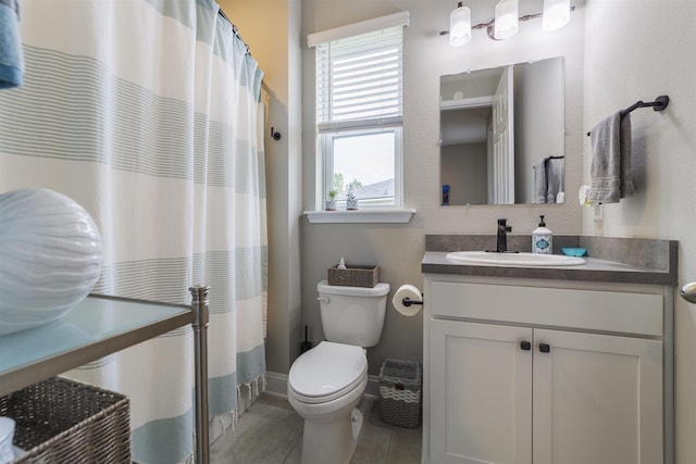 bathroom featuring tile patterned floors, vanity, and toilet