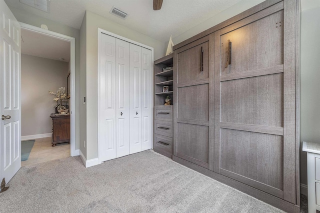 unfurnished bedroom with ceiling fan, a closet, and light colored carpet